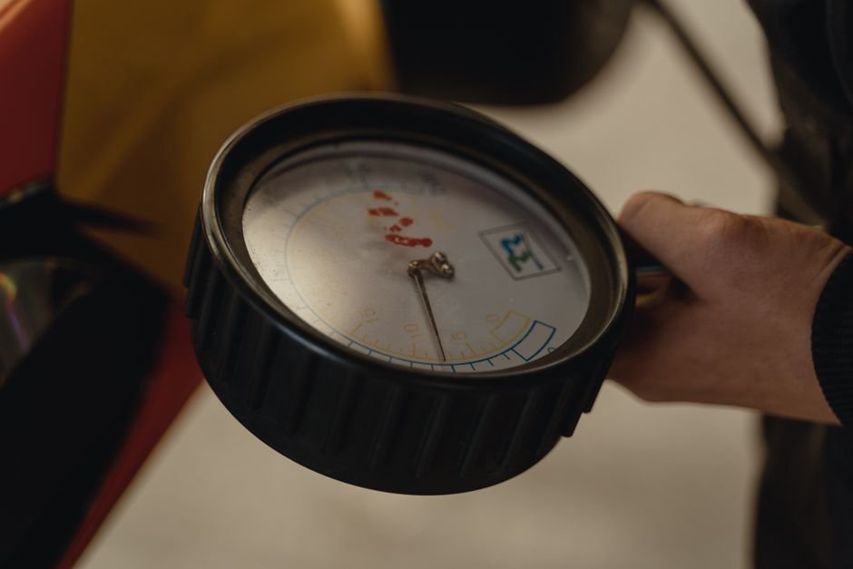 Hand holding an analogue pressure gauge, the kind of check worth doing on a boiler before calling out a Motherwell heating engineer