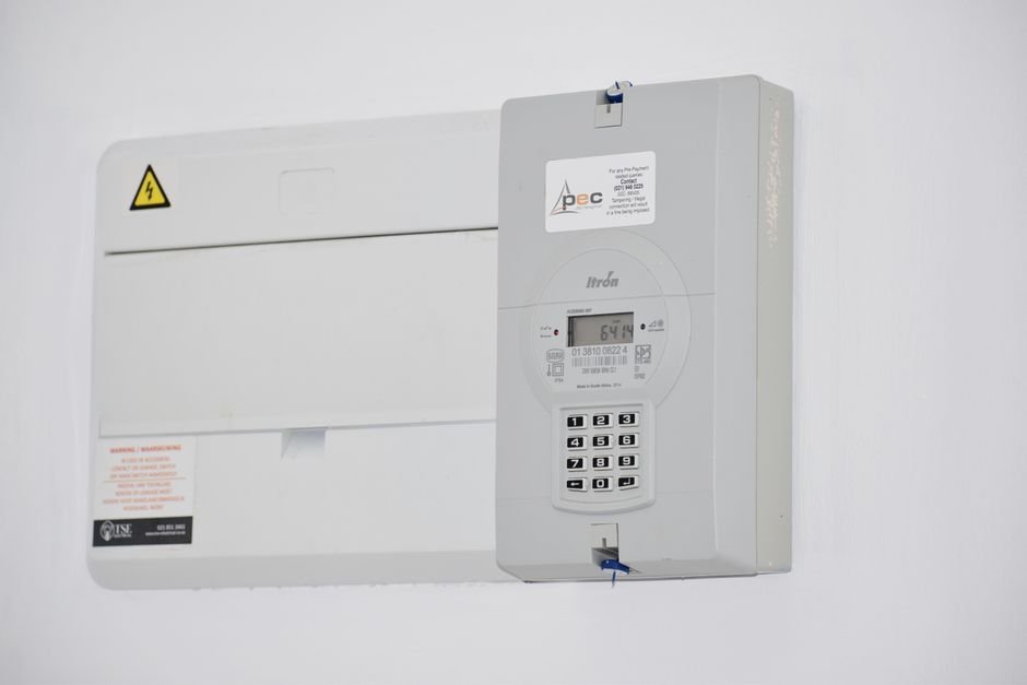 Electrical meter and consumer unit mounted on a wall, the kind of fuse board an EICR checks in East Kilbride homes