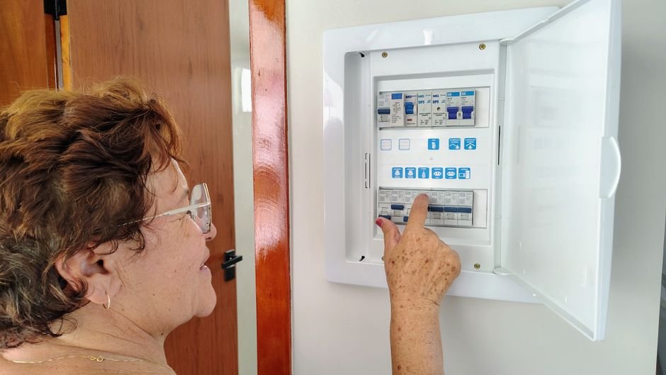 Person adjusting a home electrical fuse panel in Ayr