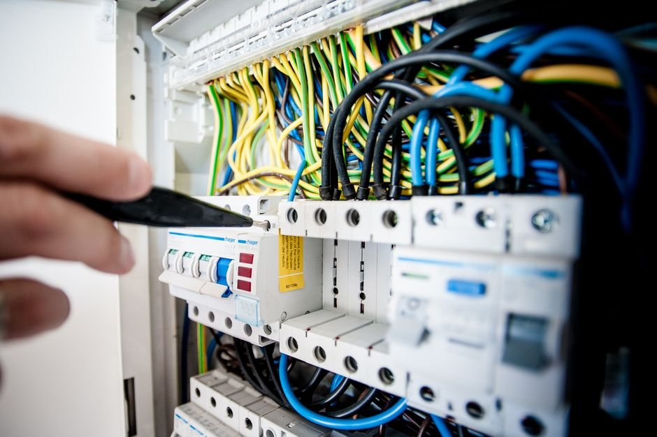 Electrician's hand working inside an open switchboard, fixing wiring faults similar to jobs local Cathcart electricians handle