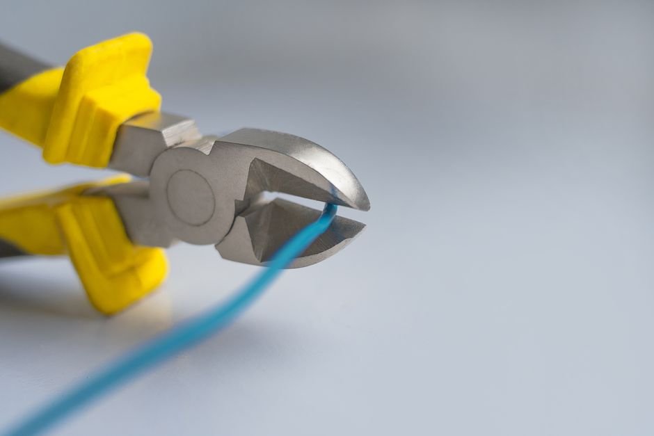 Close-up of an electrician's pliers cutting an electrical wire, the kind of rewiring and consumer unit work Motherwell and Wishaw electricians handle