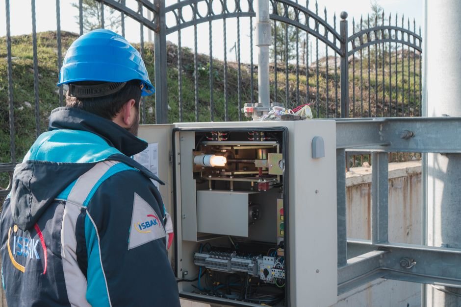 Electrician wearing a hard hat inspecting a fuse box during an installation in Rutherglen