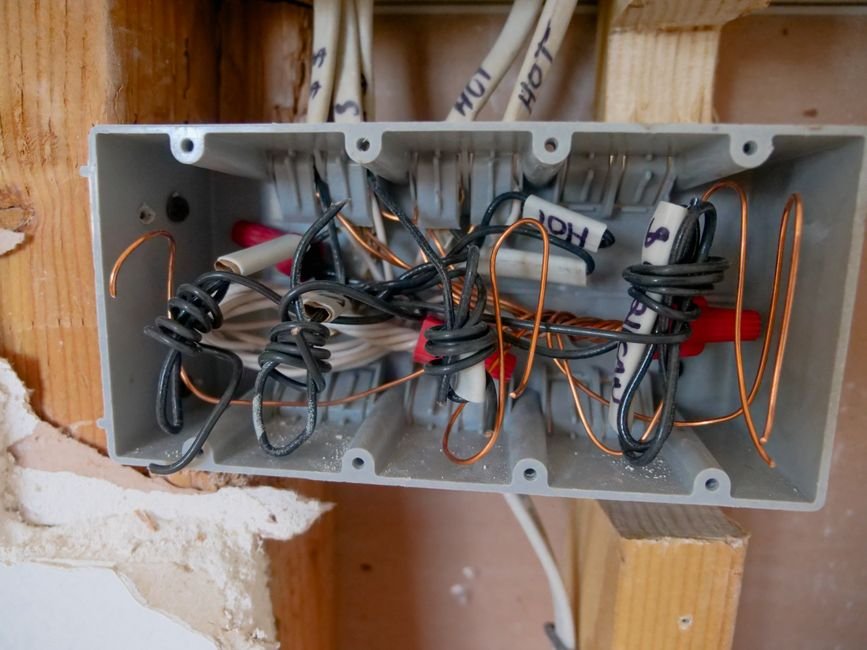 Close-up of an open electrical switchboard with wiring, the kind of consumer unit and fuse board work a Milngavie electrician carries out