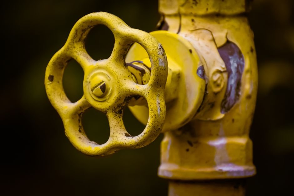 Close-up of a yellow shut-off valve, similar to a stopcock used to isolate water during a burst pipe