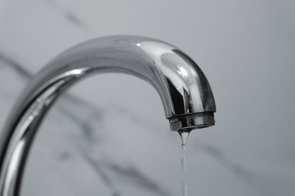Close-up of a dripping chrome bathroom tap, a common call-out for older tenement plumbing in Partick