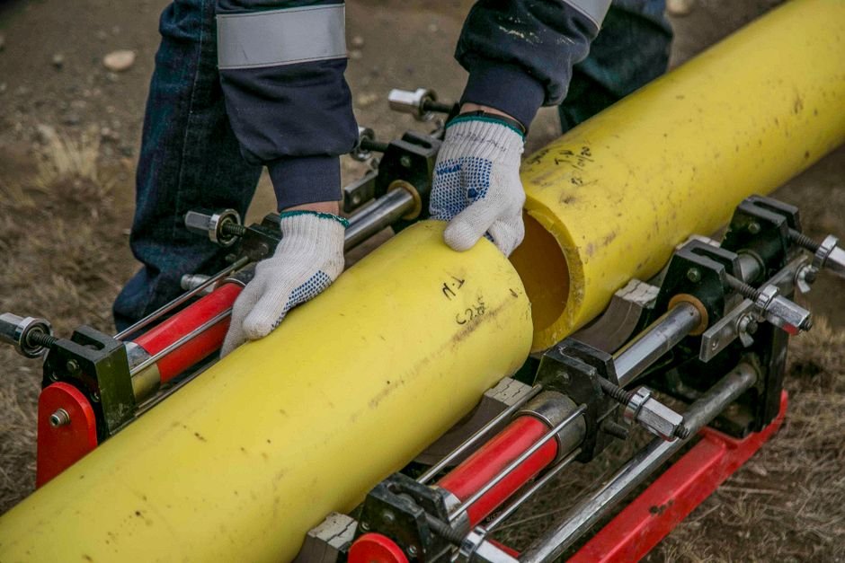 Plumber connecting pipework during a repair job, the kind of callout handled by Cumbernauld-based plumbing and heating firms