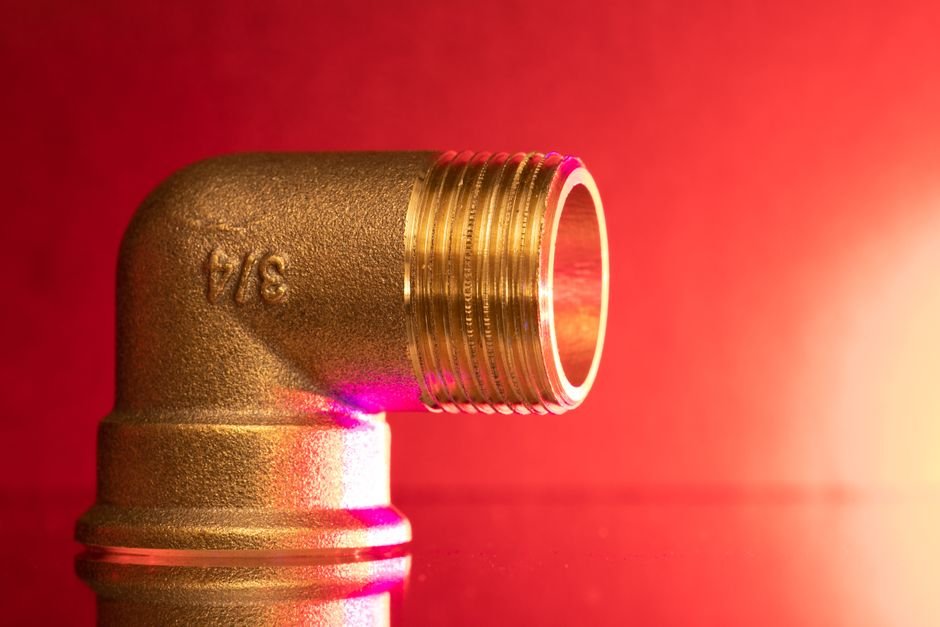 Close-up of a brass 3/4 inch pipe elbow fitting, the kind of part a plumber replaces during heating or pipework repairs in Pollokshields properties